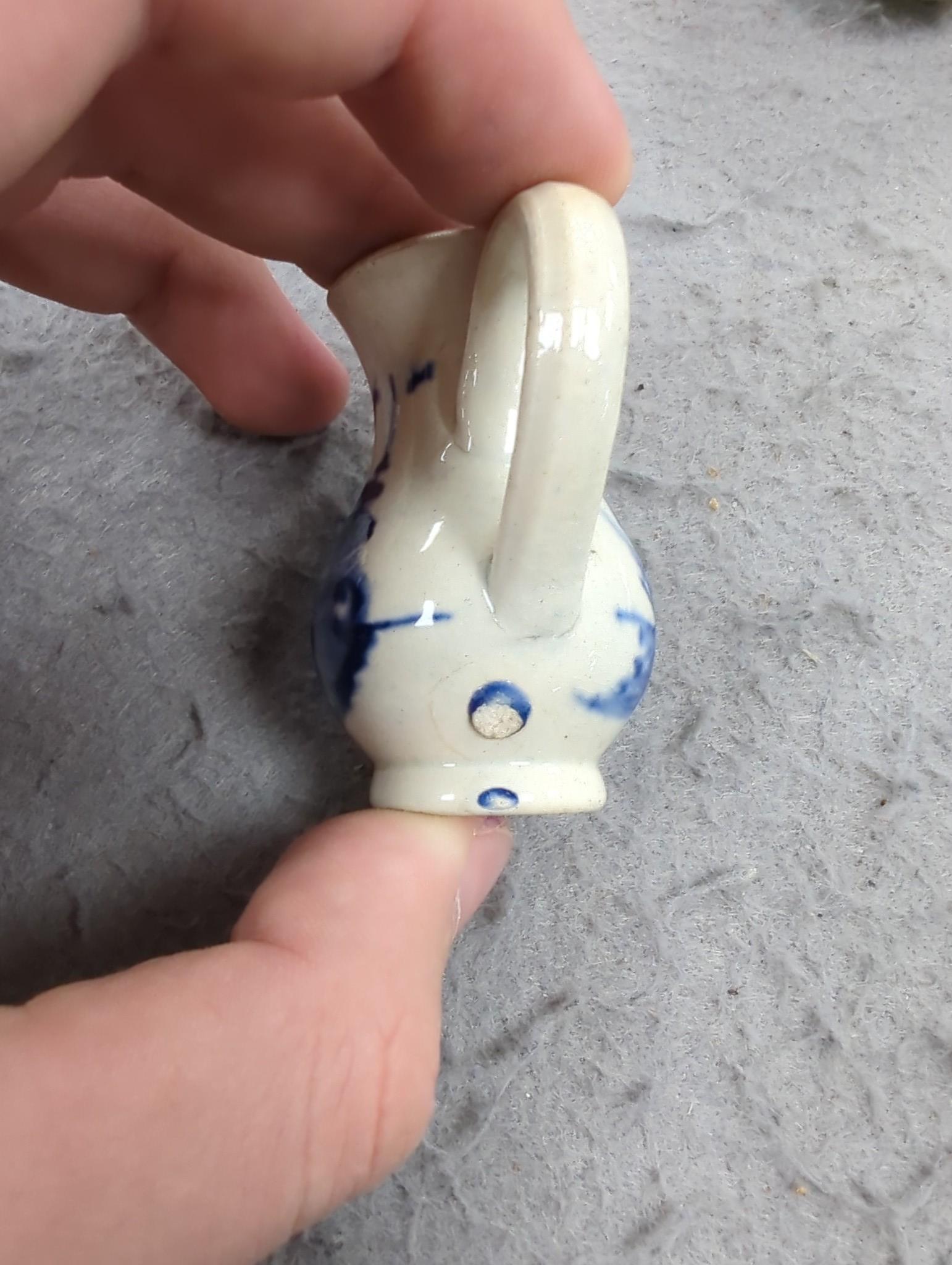 A late 18th century pearlware blue and white miniature jug, 5cm, and tea bowl and an English porcelain miniature mug, late 18th century